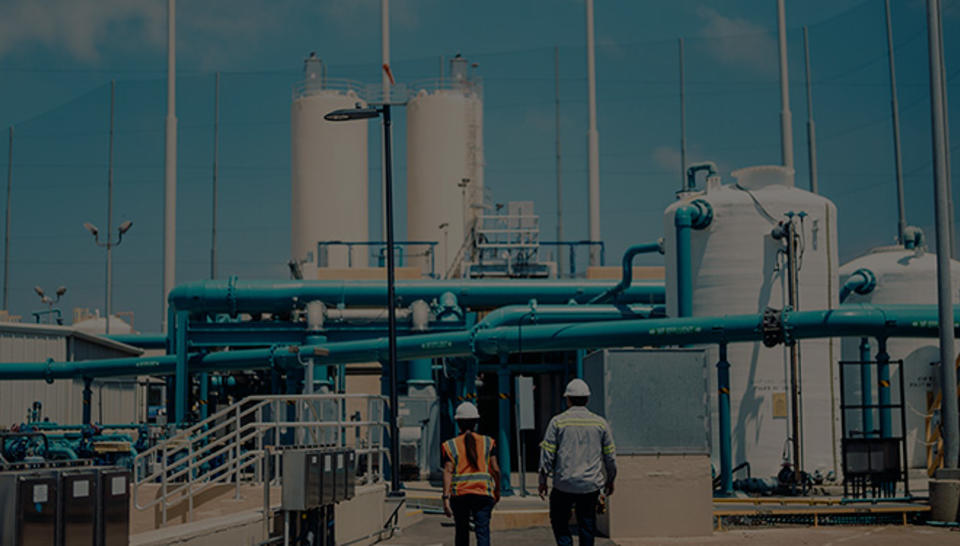 Two Veolia employees walk within a wastewater reuse facility