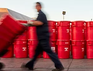 A Veolia employee working at a facility with containers
