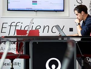 A Veolia employee sits at a desk looking at a computer