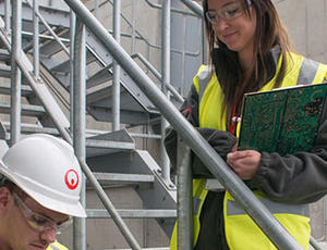 Two Veolia engineers stand in a facility, discussing plans