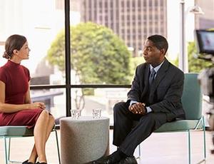 Two people sit for an interview conversation