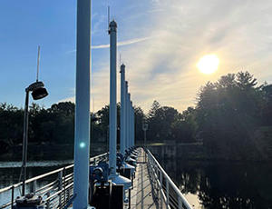 The Oradell dam is seen with a bright sun shining in the sky