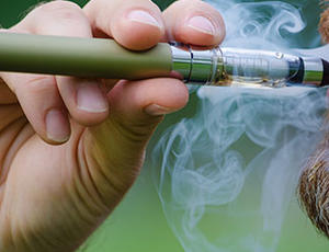 A close-up of a person smoking an e-cigarette