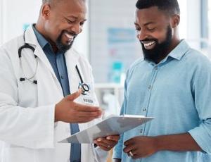 A doctor goes over results with a patient, both looking happy