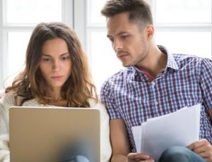 A couple looks at utility bills together in their home