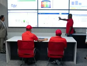 A group of Veolia experts gathers around a bank of screens in Veolia's Scottsdale, AZ Hubgrade Center
