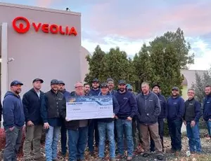 Members of Veolia's Idaho team pose with an electric rebate check worth over $128,000