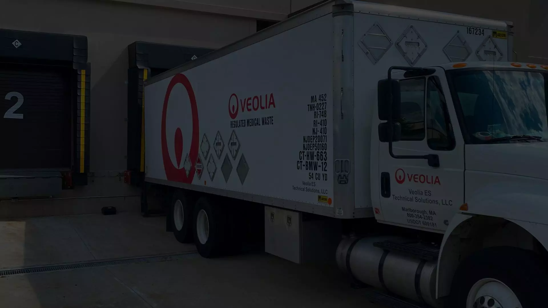 A Veolia box truck is shown parked at a loading dock
