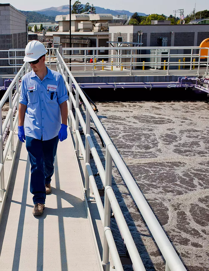 A Veolia employee is pictured standing by water infrastructure