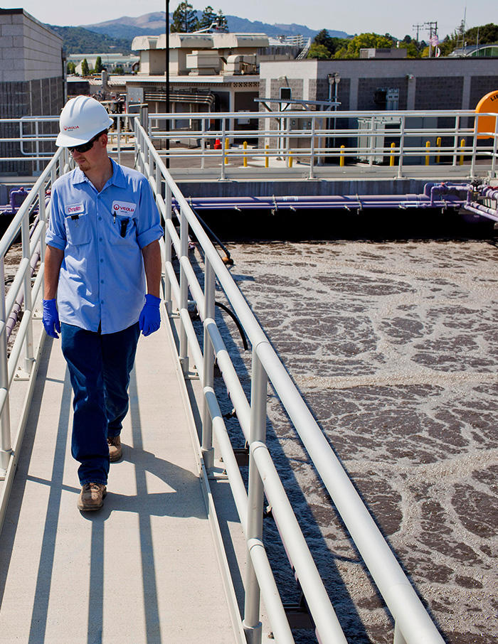 A Veolia employee is pictured standing by water infrastructure
