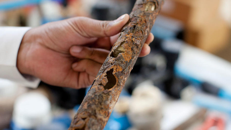Employees showing rusty pipe