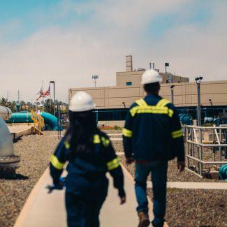 Two Veolia employees walk through a water reuse facility