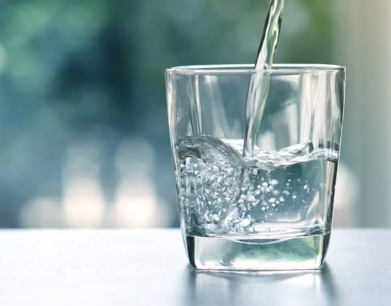 Water pouring into a glass cup