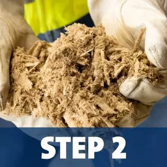 A set of hands holds shredded wind turbine blade material