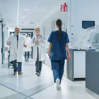 A hospital hallway with doctors and nurses walking