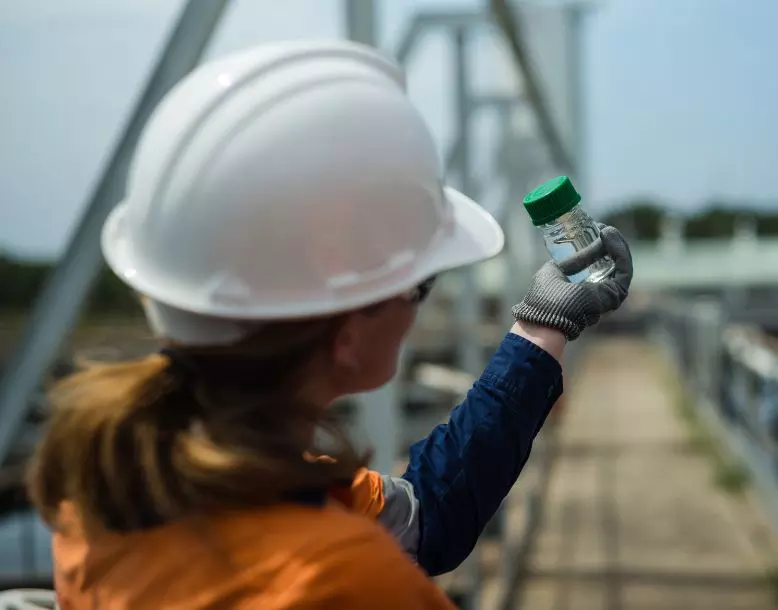 A Veolia employee holds up a vial of clear liquid