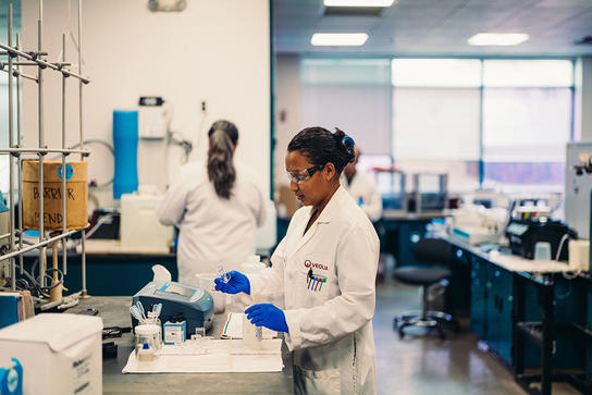 A Veolia employee works in a lab testing water quality