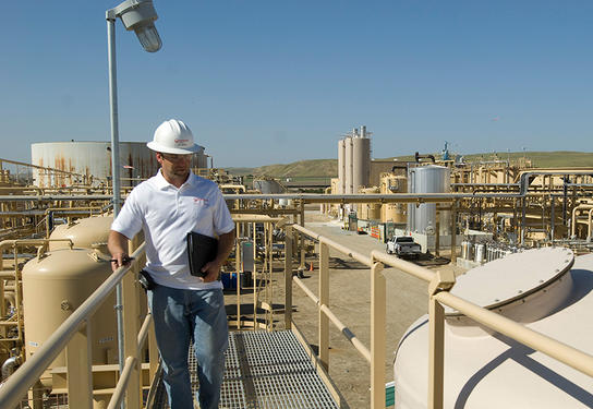 A Veolia employee is pictured standing in the San Ardo CA produced water management facility