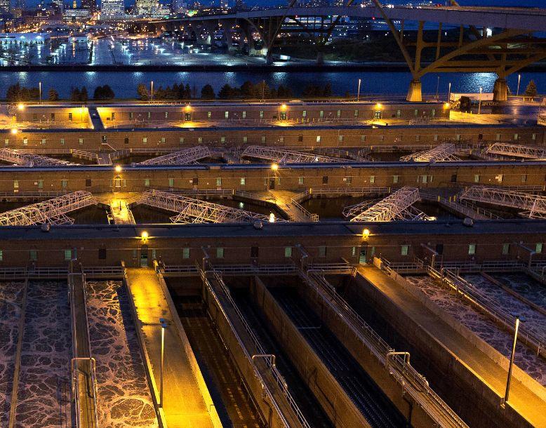 The Jones Island Water Reclamation Facility seen from above at night with Milwaukee skyline in the background