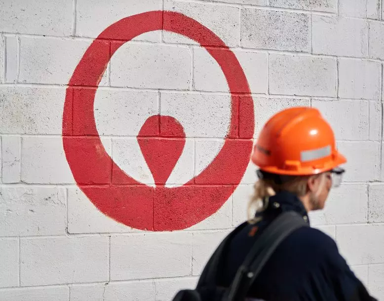 A Veolia employee walks into work past a logo painted on the wall