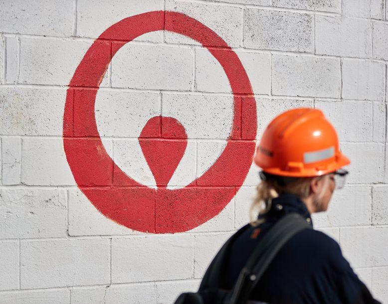 A Veolia employee walks into work past a logo painted on the wall
