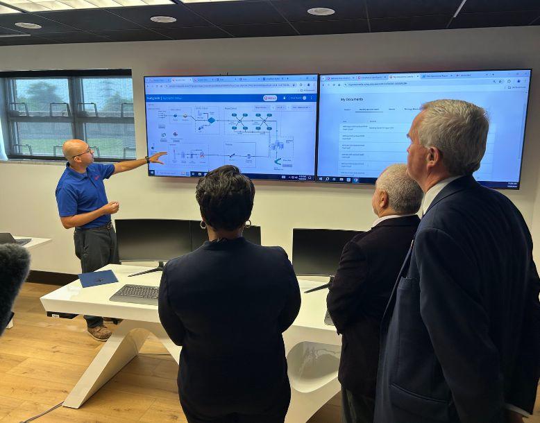 Veolia Project Manager Erick Gomez demonstrates the Hubgrade digital solution in the new control room at New Orleans’ East Bank wastewater treatment plant for, from left to right, New Orleans Mayor LaToya Cantrell, Sewerage and Water Board of New Orleans Executive Director Ghassan Korban and Veolia North America CEO Frédéric Van Heems.