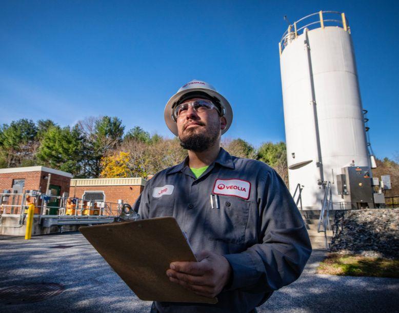 A Veolia employee works in a capital program, standing in a working water treatment facility