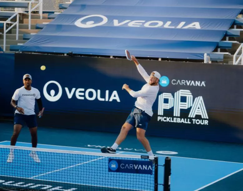 Two athletes play on a PPA court