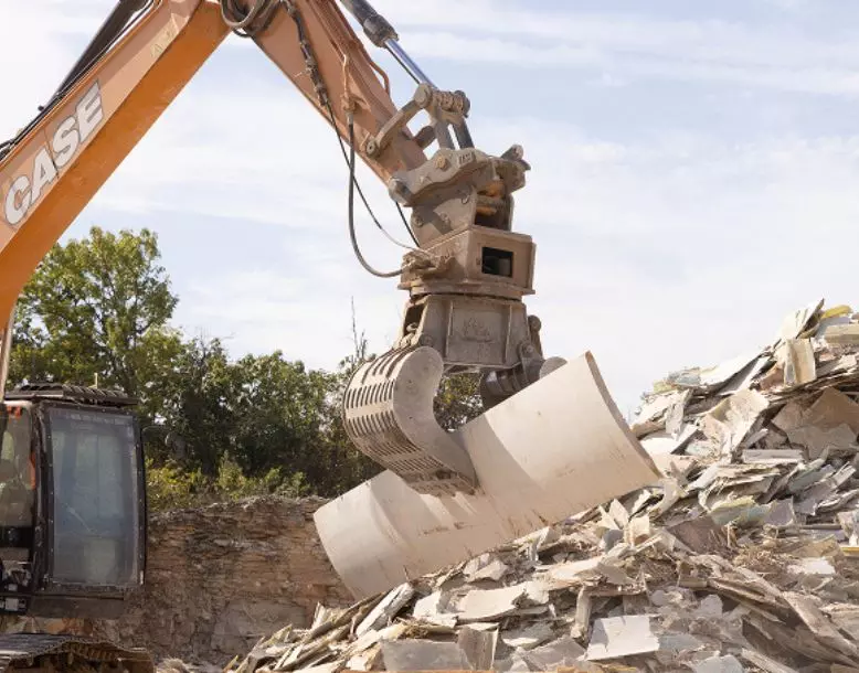 A piece of a wind turbine blade is picked up with an industrial arm